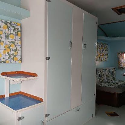 Restored caravan wardrobe bank with lemon print soft furnishings and a blue laminate bench