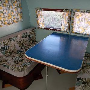 Retro caravan dinette with a blue laminate table and floral upholstery